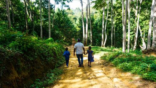 a man and two children walking down a dirt road at LUSHOTO EXECUTIVE LODGE in Lushoto
