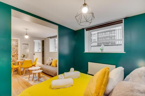 ein Wohnzimmer mit blauen Wänden und einem gelben Tisch in der Unterkunft Spacious Luxury Service Apartment Stevenage Town Centre family or business in Stevenage