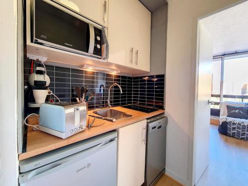 La cuisine est équipée d'un évier et d'un grille-pain. dans l'établissement Studio agréable Ski au pieds Balcon - FR-1-344-997, aux Menuires