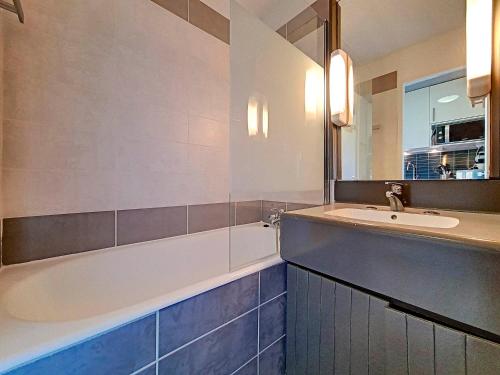 une salle de bain avec un lavabo et une baignoire dans l'établissement Studio agréable Ski au pieds Balcon - FR-1-344-997, aux Menuires