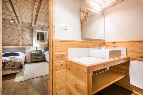 ein Badezimmer mit Waschbecken und ein Bett in einem Zimmer in der Unterkunft Casa Pleta de Baqueira Deluxe by Totiaran in Naut Aran