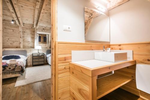 a bathroom with a sink and a bed in a room at Casa Pleta de Baqueira Deluxe by Totiaran in Naut Aran