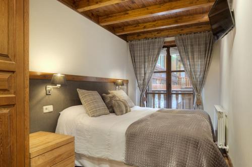 un dormitorio con una cama y una ventana en Bonaigua by Totiaran, en Naut Aran (Alto Arán)