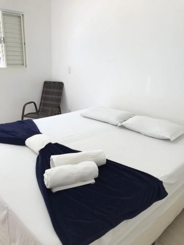 a bedroom with two white towels on a bed at Pousada Trilha do Sol in Pirenópolis