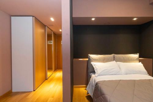 um quarto com uma cama grande e um corredor em Originals - parcheggio GRATIS in struttura e colazione inclusa em Turim