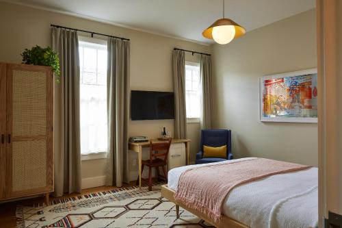 a bedroom with a bed and a desk and a tv at Hotel Kinsley in Kingston