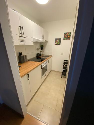a small kitchen with white cabinets and a tile floor at Design, Hochschule, Wildpark, Zentral, Waipu TV, Netflix in Pforzheim