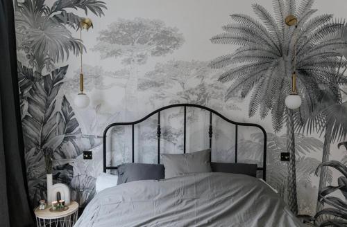 a bedroom with a bed and a palm tree wallpaper at Au Numéro 5 in Tilff
