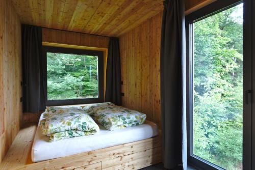 a bed in a room with a window at Baumwipfel-Resort "Lug ins Land" in Ilsenburg