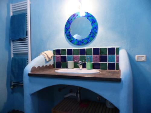 グレーヴェ・イン・キアンティにあるCasa Benincasa Chiantiの青いバスルーム(シンク、鏡付)