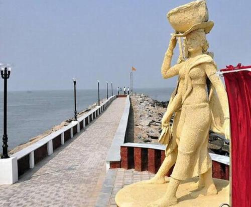 a sand sculpture of a person standing on a pier at Gruham Malpe Homestay Udupi in Malpe