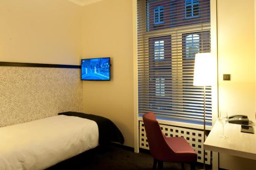 a hotel room with a bed and a window at Hotel Topas Frankfurt City in Frankfurt/Main