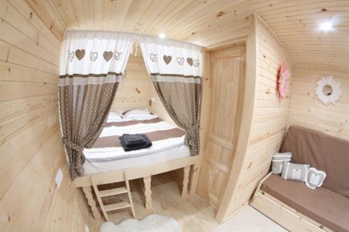 a small room with a bed in a wooden cabin at Roule hôtes in Montéglin