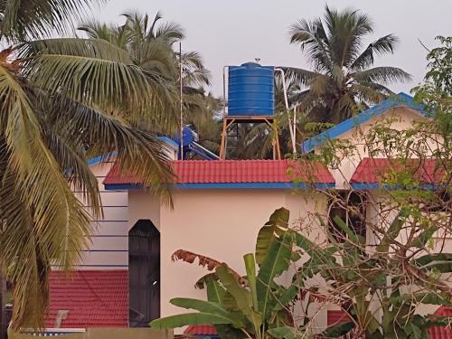 a house with a blue barrel on the roof at Gruham Malpe Homestay Udupi in Malpe