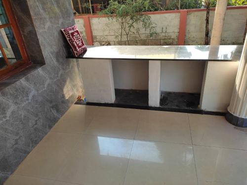 a tiled floor with a bench in a room at Gruham Malpe Homestay Udupi in Malpe