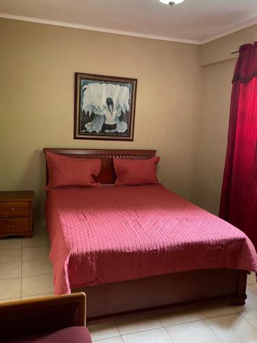 a bedroom with a bed with a red bedspread at Canal Inn B&B Panama in Panama City