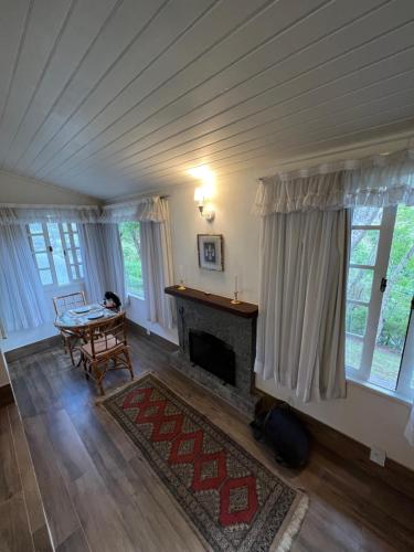 a living room with a fireplace and a table at Chalés da montanha in Itaipava