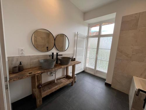 een badkamer met twee wastafels en twee spiegels aan de muur bij Gite du Prieuré in Chagny