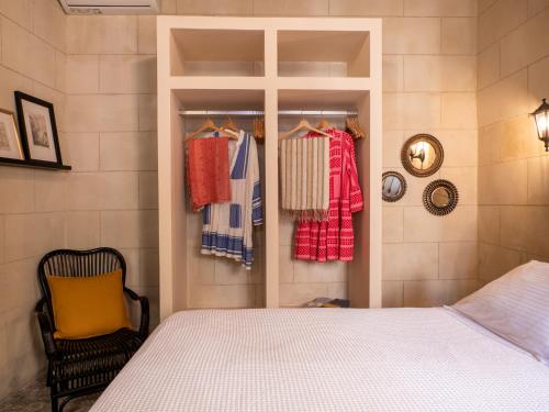 ein Schlafzimmer mit einem Bett und einem Kleiderschrank mit Kleidung in der Unterkunft Casa Theano - Old Town in Rhodos (Stadt)