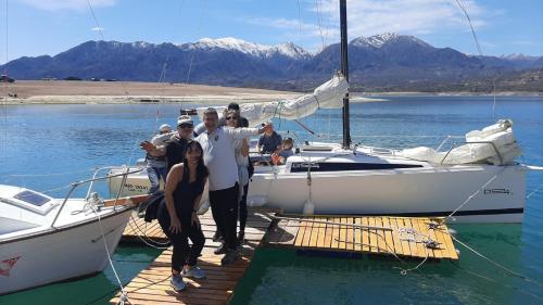 a group of people standing on a dock next to boats at La Calma Ecolodge in Las Heras
