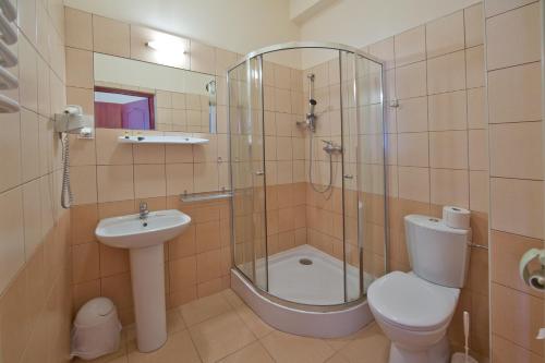a bathroom with a toilet and a shower and a sink at Hotel Kameralny in Kielce