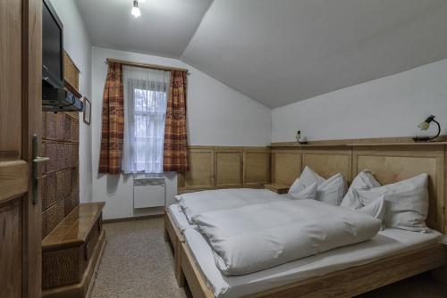 1 dormitorio con 1 cama grande y TV en Boróka Apartmanházak - Öregház en Velem