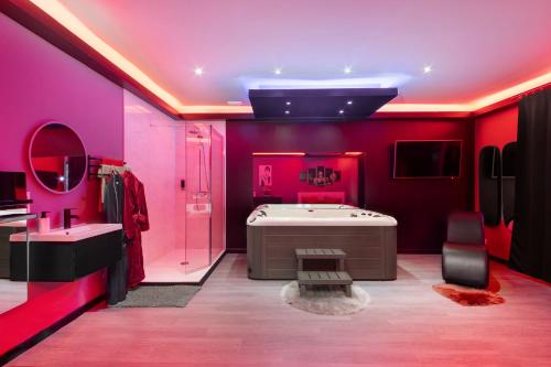 - une salle de bains rose avec baignoire et lavabo dans l'établissement Secret Night, à Toulouse