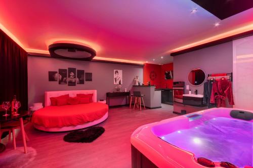 - une chambre avec un lit rouge et une baignoire dans l'établissement Secret Night, à Toulouse