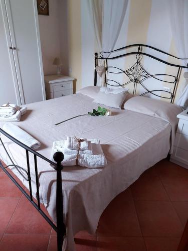 a bed with white sheets and shoes on it at Donnigheddu in Rudalza