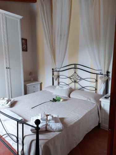 a bedroom with a bed with white sheets and a table at Donnigheddu in Rudalza