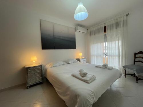 a bedroom with a large bed with a tv on the wall at Praia Mar in Monte Gordo