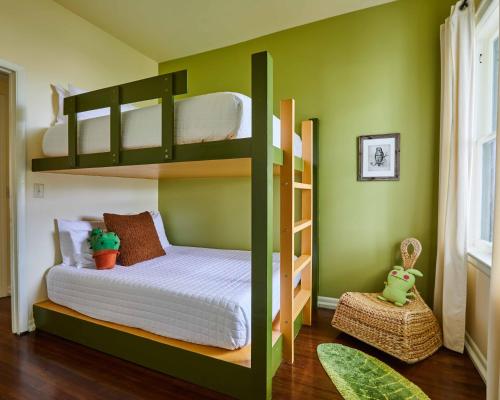 a green bedroom with bunk beds in a room at Eden Brae: Historic Southern Gothic Mansion in Birmingham