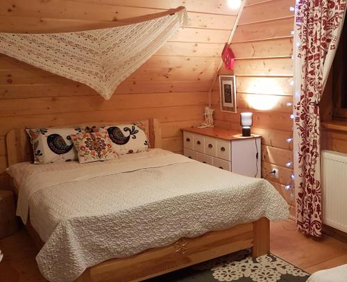 a bedroom with a bed in a log cabin at Chata Albertówka in Groń