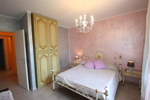 Un dormitorio con una cama con almohadas moradas y una lámpara de araña. en Cà Di Toni, en Testana