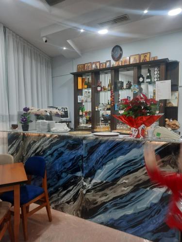 a room with a counter with a painting of the ocean at HOTEL MEGNIAR in Lushnjë