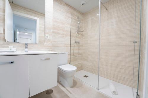 a bathroom with a toilet and a glass shower at Aqua Apartments Bellamar, Marbella in Marbella