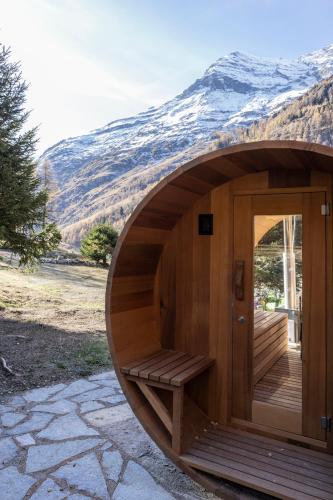 a wooden sauna with a wooden door and a mountain at Polaris appartement 2 in Zinal
