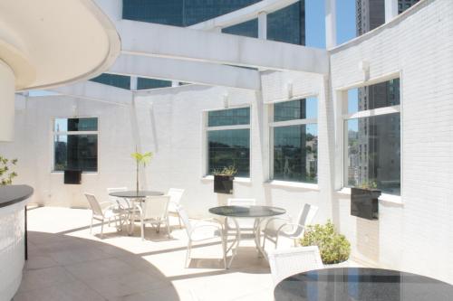 d'une terrasse avec des tables, des chaises et des fenêtres. dans l'établissement Hotel Atlântico Tower, à Rio de Janeiro