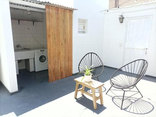 a patio with two chairs and a table and a washing machine at Buenaventura Apartments Terrazas in Mendoza