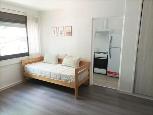 a small bedroom with a bed and a refrigerator at Buenaventura Apartments Terrazas in Mendoza
