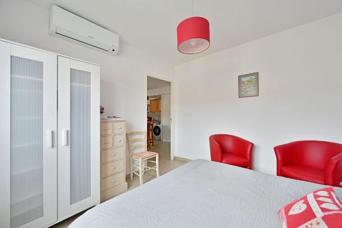 1 dormitorio con 1 cama y 2 sillas rojas en Îlot COQUELICOT - PARKING GRATUIT SECURISE - AC CLiM - ASCENSEUR - BALCON, en LʼIsle-sur-la-Sorgue