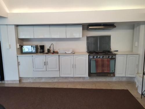 a kitchen with white cabinets and a stove at Hermoso Loft espectacular vista BosquesdelasLomas in Mexico City