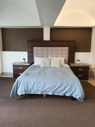a bedroom with a large bed with two night stands at Hermoso Loft espectacular vista BosquesdelasLomas in Mexico City