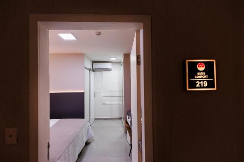 a small room with a bed and a sign on the wall at Tonello Business Hotel in Campo Mourão
