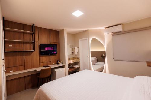 a hotel room with a bed and a tv in it at Tonello Business Hotel in Campo Mourão