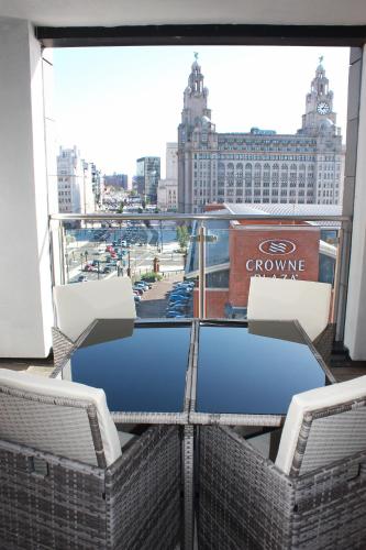 a balcony with chairs and a view of a city at NOVU Apartments Liverpool Waterfront in Liverpool