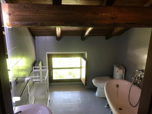 baño con aseo y ventana en The Gulf Sailor's Cottage - Lago Maggiore, en  Monvalle 