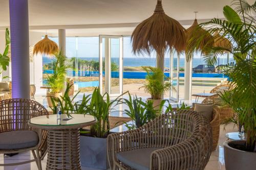 a restaurant with chairs and tables and a view of the ocean at SYRAH Premium B2 - Piscina privada con vista al mar by depptö in Punta del Este
