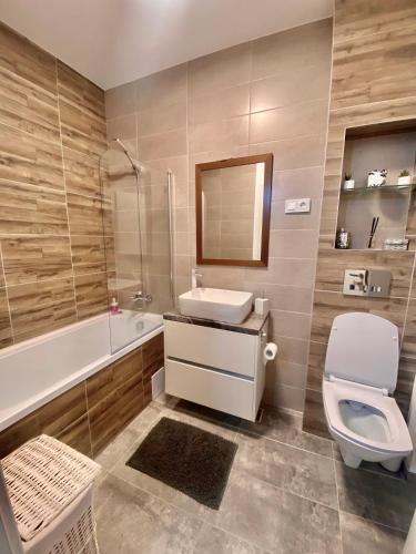 łazienka z umywalką, toaletą i wanną w obiekcie Velvet Studio w mieście Târgu Mureş