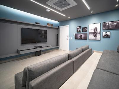 a living room with a couch and a flat screen tv at Estúdio Lindíssimo com Varanda! in Curitiba